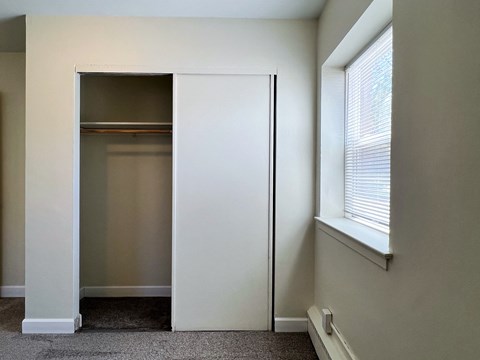 a closet in the corner of a room with a window and